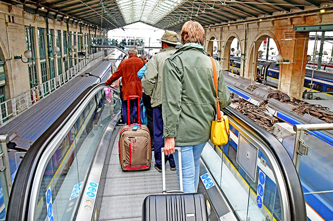 People walking to escalator leading down to train platform