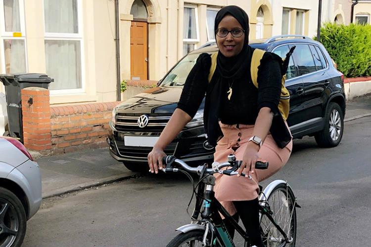 Abiir riding bicycle down the street.