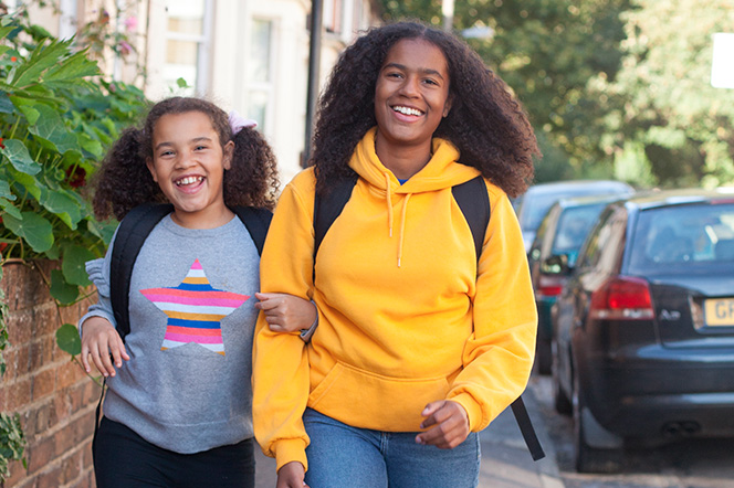 Two sister walking along a pavement in Bristol