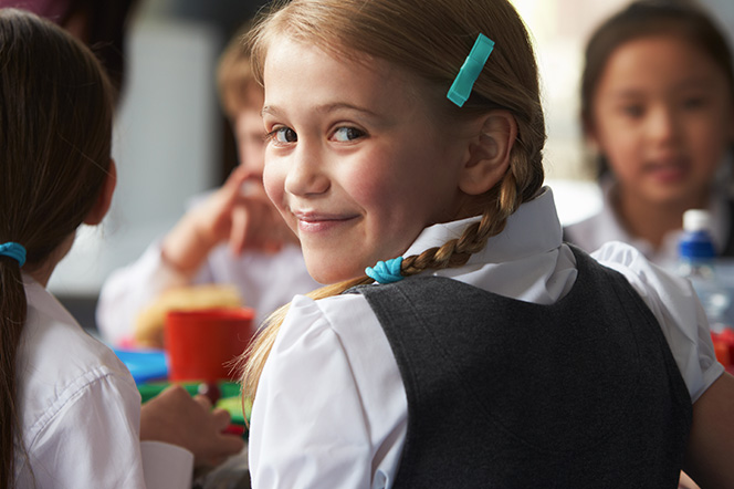 Young girl in school uniform smiling at camera